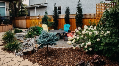 Colorful patio with plants, flowers, and gravel. Photo